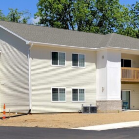 Completed two-story Keystone Lake Apartments home with balconies in a wooded setting, Battle Creek, MI